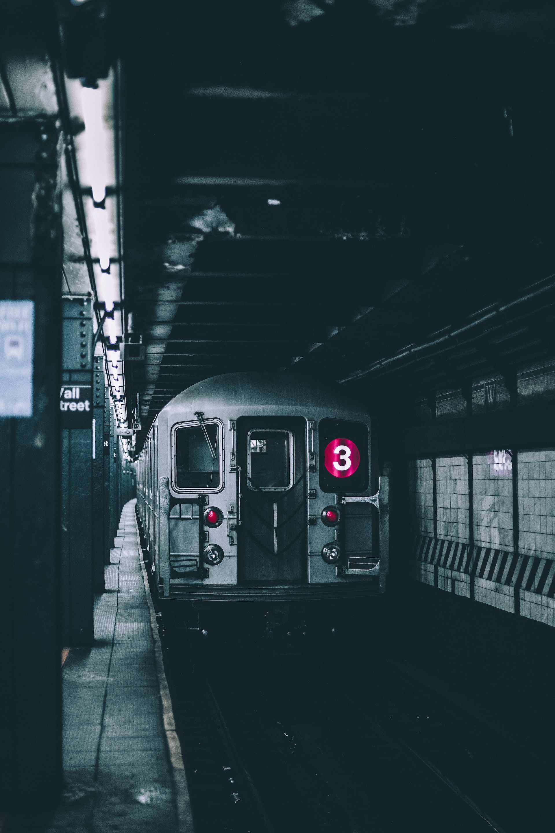 NYC Subway Red Line train at an underground station. Photo by Andre Benz