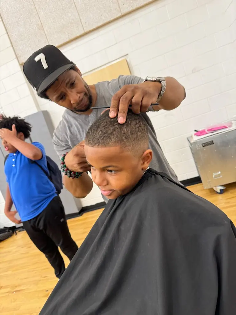 Kennard chatting with a child during a haircut